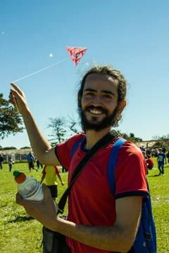Smiling man playing with a kite Stock Photos