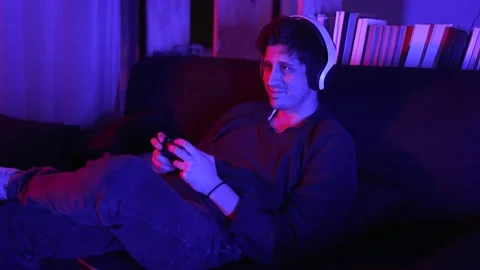 Smiling man playing video games at home with focus to his hands and game control Stock Footage 199128985