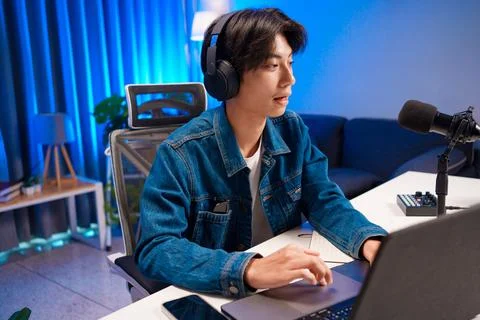 Smiling man podcaster make audio podcast with headphones and microphone in Foto stock