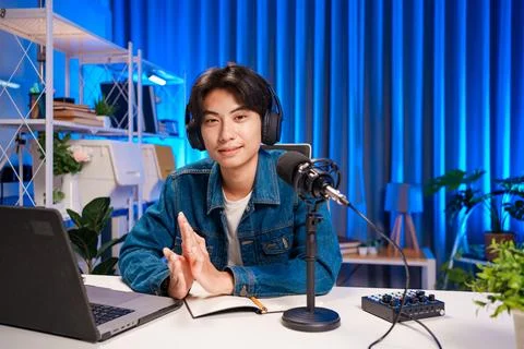 Smiling man podcaster make audio podcast with headphones and microphone in Foto stock
