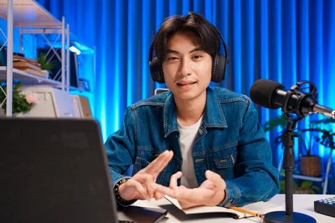 Smiling man podcaster make audio podcast with headphones and microphone in Foto stock
