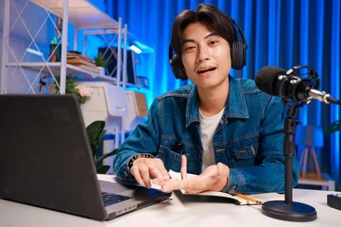 Smiling man podcaster make audio podcast with headphones and microphone in Foto stock