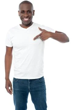 Smiling man pointing at blank white t-shirt Fotos Stock