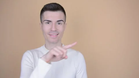 Smiling Man Pointing Finger to the Side on Isolated Background Stock Footage 249336700