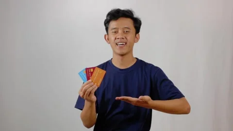 Smiling man presenting multiple credit cards Stock Footage 318430997