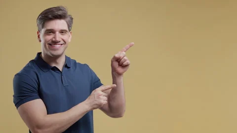 Smiling man presenting something isolated on beige background. Portrait of guy,  Stock Footage 341768038