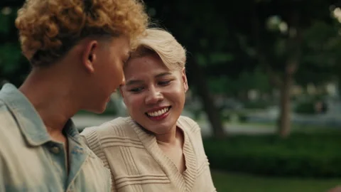 Smiling man puts head on partner shoulder resting in park Video stock 278238570