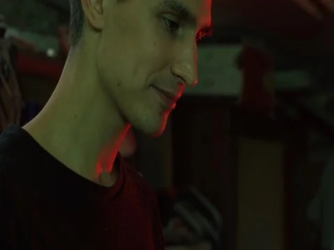 Smiling Man Puts on Headphone Before Work under Neon light Stock Footage 73663613