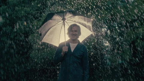 Smiling man in the rain with an umbrella Stock Footage 279062567
