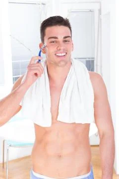 Smiling man shaving face with razor Stock Photos