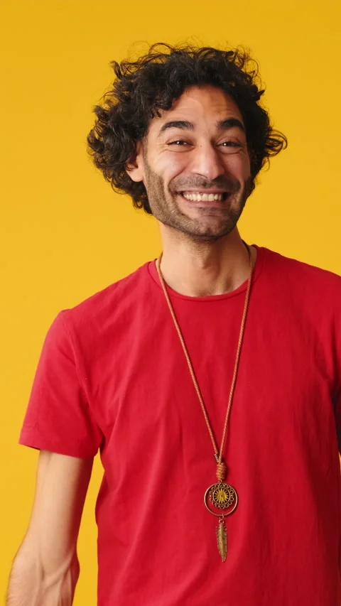 Smiling man showing double thumbs up looking at camera isolated on yellow Stock Footage 263653670