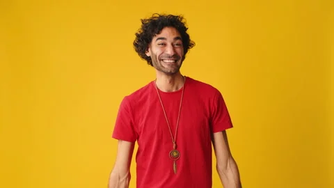 Smiling man showing double thumbs up looking at camera isolated on yellow Stock Footage 267313485