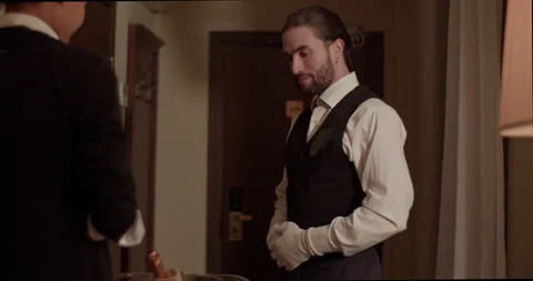 Smiling man showing order to female guest during room service at hotel Stock Footage 233190894