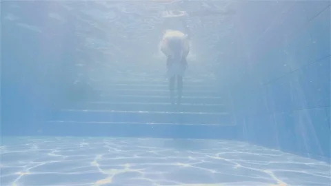 Smiling man showing thumbs up while swimming under water in pool of resort hotel Stock Footage 108519224