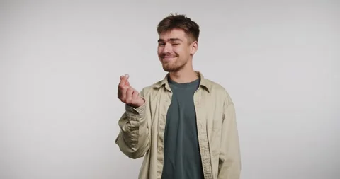 Smiling man shows appreciation while holding a small object in a studio set.. Video stock 331989784