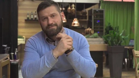 Smiling man shows ok to camera, in pub, cafe, indoor, steadicam shot 库存影片 73067486