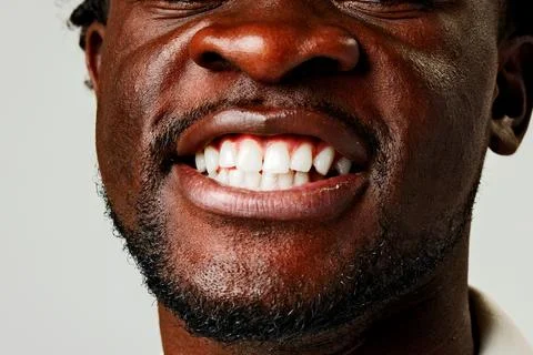 Smiling man shows white teeth with clear background in indoor setting Stock Photos