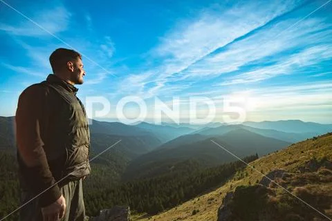 The smiling man standing on the beautiful mountain landscape background Stock Photos