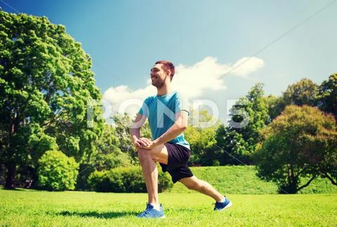 Smiling man stretching outdoors Stock Photos