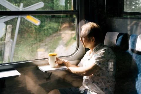 A smiling man in a suburban train looking out the train window Stock Photos