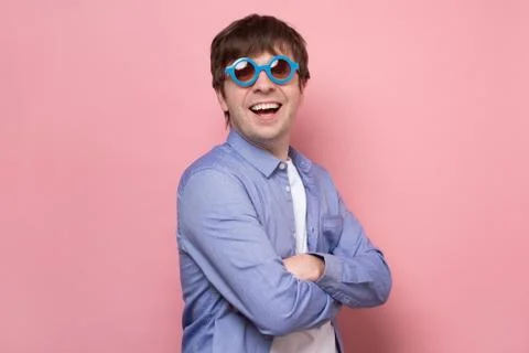 Smiling man in sunglasses posing in studio and looking at camera Stock Photos