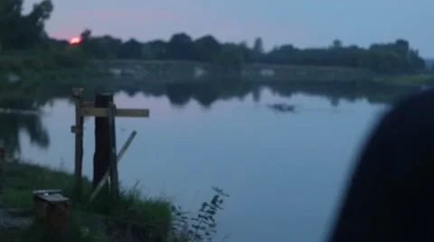Smiling man on sunset on the river Stockbeeldmateriaal 53569092
