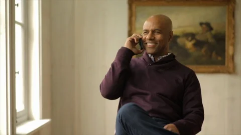 Smiling man talking on a cellphone. Vidéo 88406176