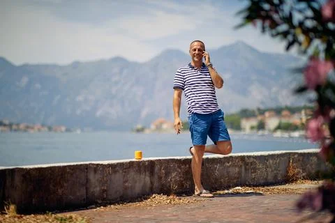 Smiling man talking on his mobile phone atvacation journey. Stock-Fotos