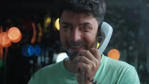 Smiling Man Talking on Phone in a Dimly Lit Atmosphere Stock Footage 312227949