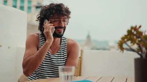 Smiling Man Talks on Phone on City Balcony Stock Footage 332257991