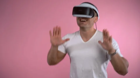 Smiling man testing virtual reality headset and dancing gesturing with hands on Stock-Footage 122775922