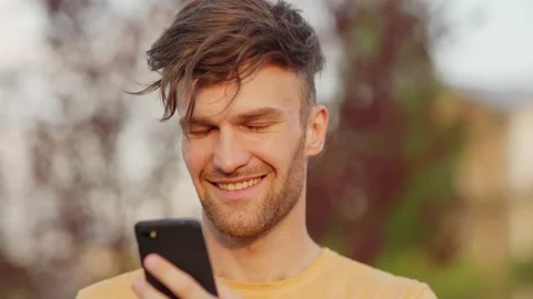 Smiling man texting and looking away outdoors Video stock 132726788
