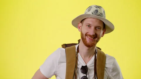 Smiling Man With Tourist Backpack, Hat And Camera Standing, Crosses His Arms Stock Footage 170185193