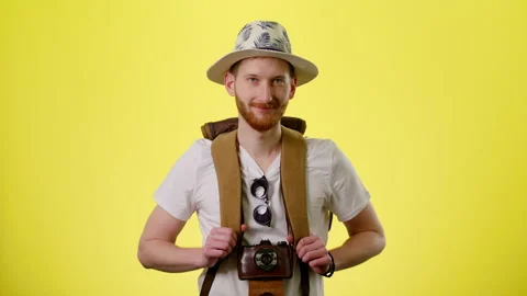 Smiling Man With Tourist Backpack, Hat And Camera Standing And Looking At Camera Stock Footage 170186032