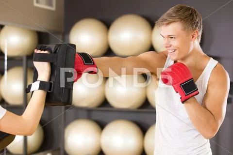 Smiling man training boxing at the fitness gym Stock Photos