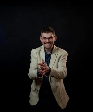 Smiling man with tree-day stubble claps hands in studio Stock Photos