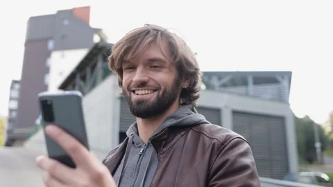 Smiling Man Typing Message on Smartphone while Standing on the Street. Sending Stock-Footage 151030425