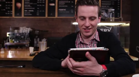Smiling man typing on a tablet PC at cafe Stock-Footage 61217080