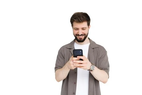 Smiling man use his mobile phone while standing on white background Stock Photos