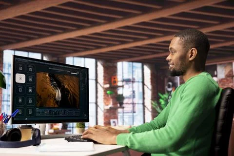 Smiling man using AI program turning text prompt into videos, pleased by results Stock Photos