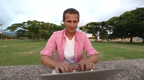 Smiling Man Using Computer In The Park Stock Footage 55816527