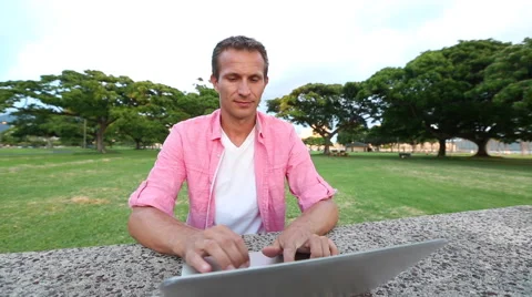 Smiling Man Using Computer In The Park Stock Footage 55817931