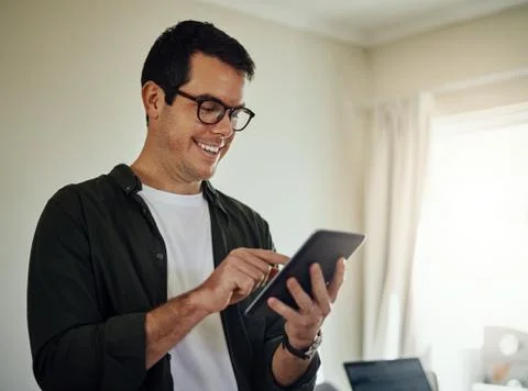Smiling man using digital tablet at home Stock Photos