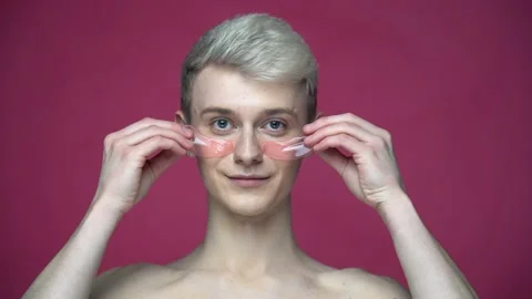 Smiling man using eye patches for fresh skin isolated on red background Stock-Footage 155462241