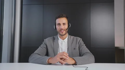 Smiling man using hand gestures during video call. Caucasian man sitting in 스톡 동영상 164469100