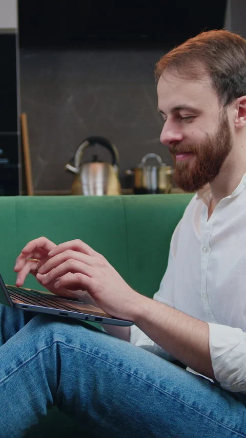 Smiling man using laptop checking email news or searching for friends in interne Stock Footage 333329396