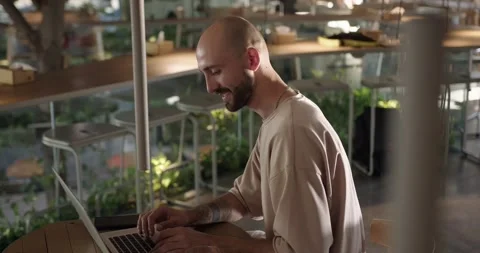 Smiling man using laptop for remote work at cafe Stock Footage 159082142