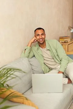 Smiling Man Using Laptop At Sofa. Guy Relaxing With Laptop At Home On Cozy Couch Stock-Fotos
