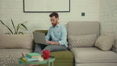 Smiling man using laptop typing look at camera waving his hand wants to show Stock Footage 132539690