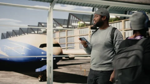 Smiling man using smartphone in airport to talk with friends Stock Footage 336669334